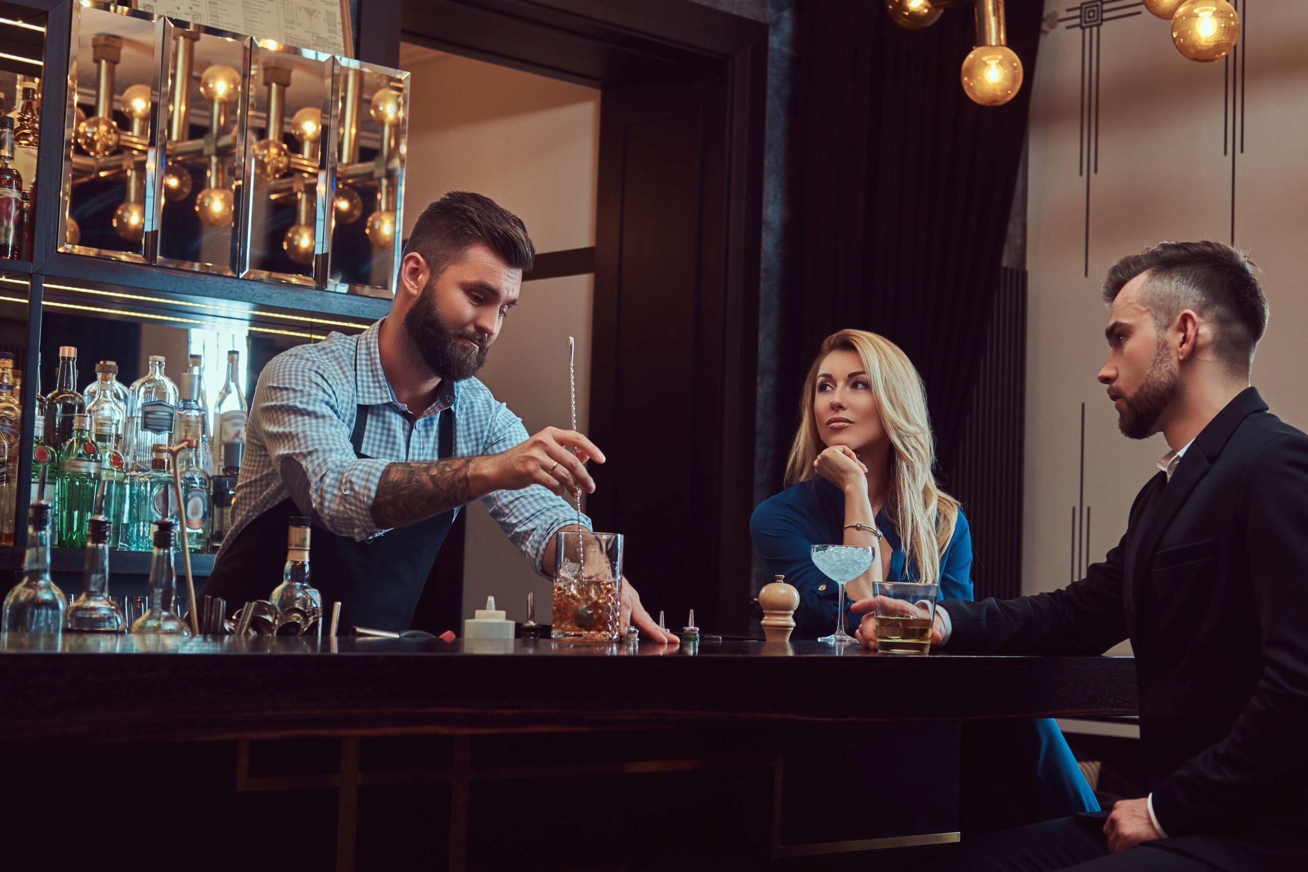 Stylish brutal barman serves an attractive couple who spend an evening on a date.